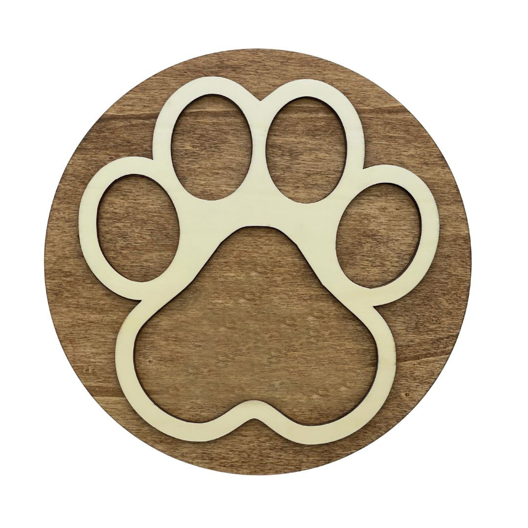Placa de madera oscura circular con detalle superpuesto de una huella de mascota en madera clara.