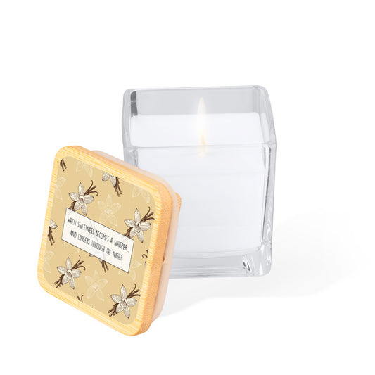 Vela aromática en tarro de cristal cuadrado con tapa de bambú. Diseño impreso: fondo color crema con flores y vainas de vainilla dibujadas a mano y en un rectángulo blanco centrado, la frase "When sweetness becomes a whisper... and lingers through the night."