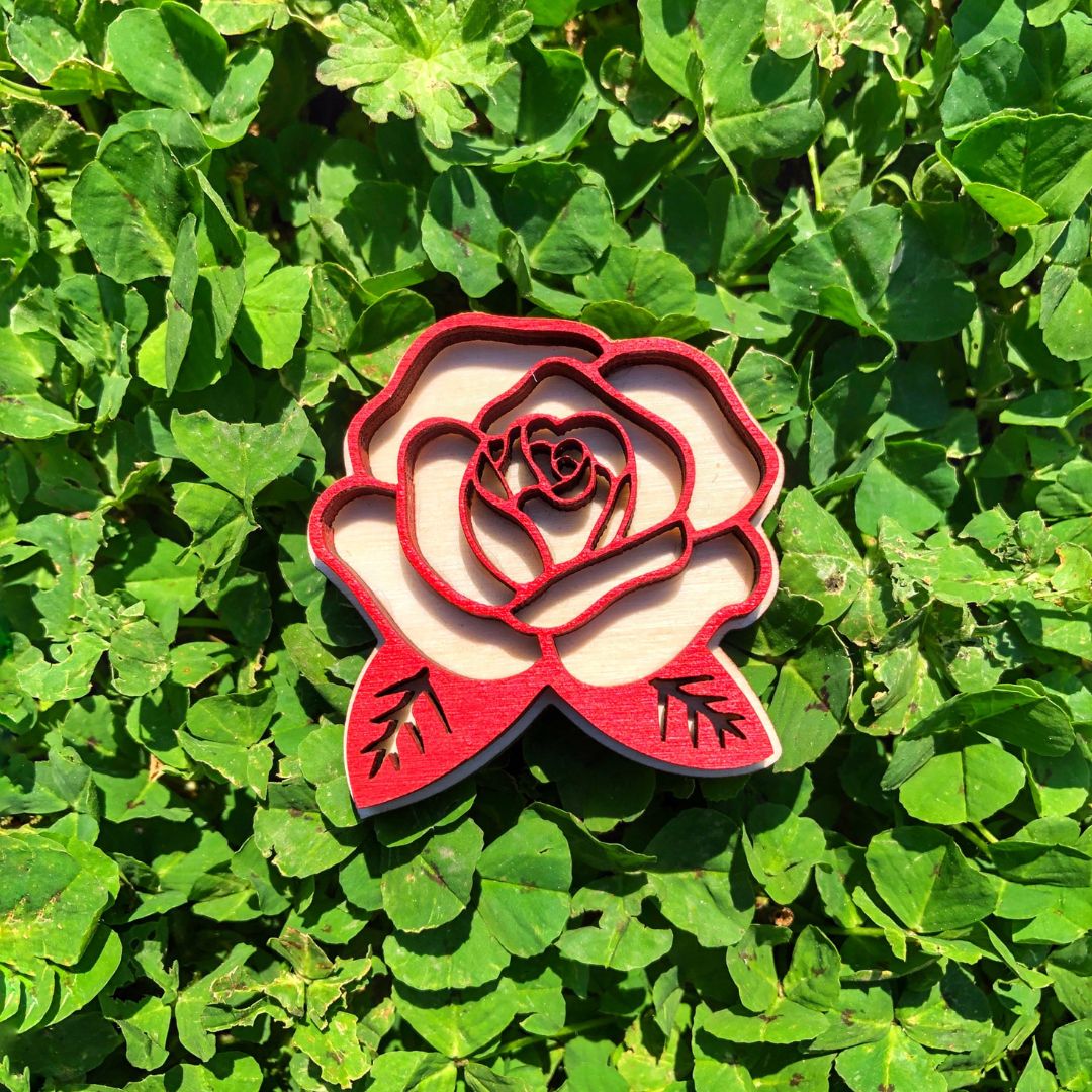 Imán de madera con forma de rosa de Sant Jordi en relieve rojo, diseño artesanal disponible en dos modelos —abierta o cerrada—, ideal como recuerdo sostenible y decorativo. Modelo abierto