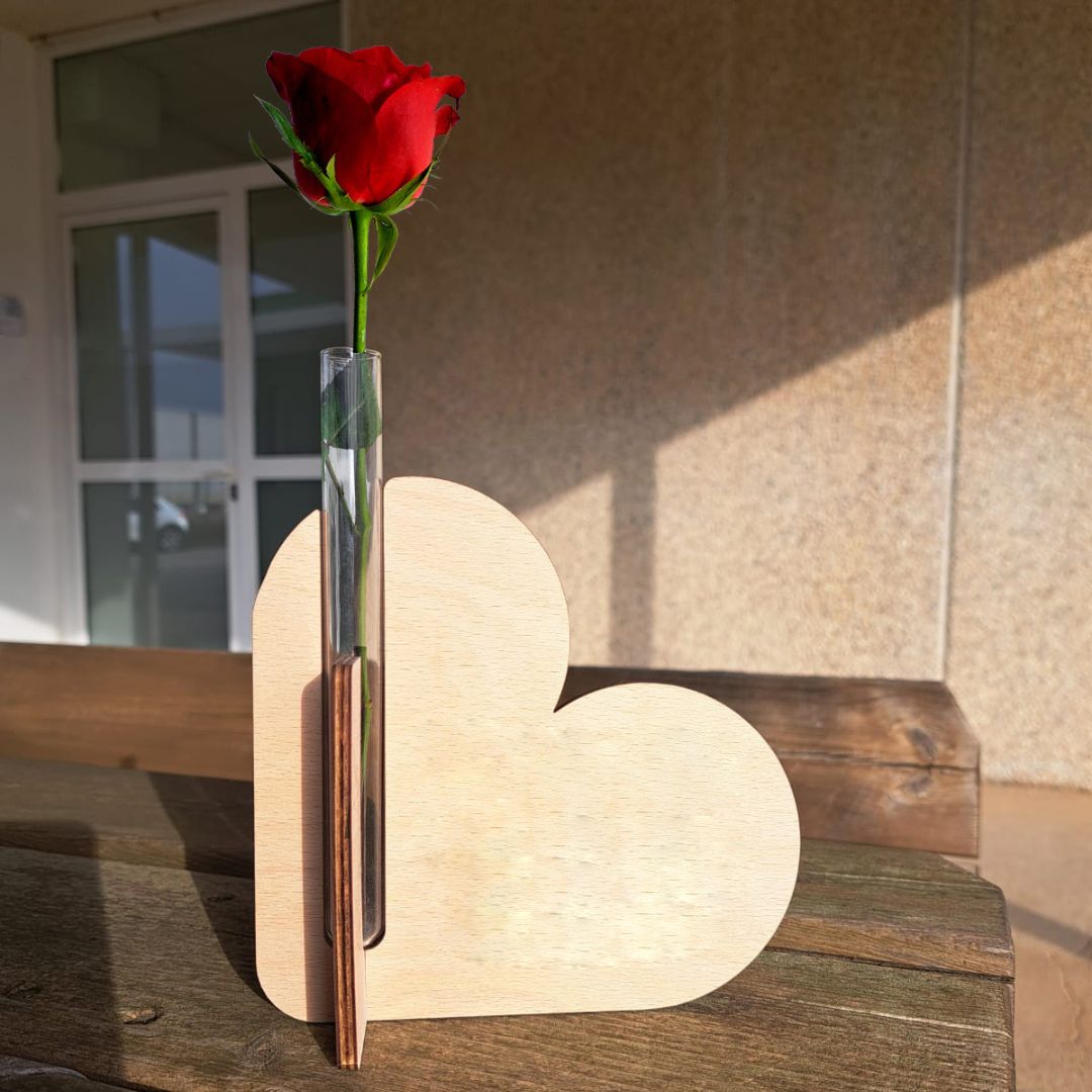Porta rosas de madera formado por dos corazones cruzados y un tubo de cristal para poner la rosa con agua. Personalizado con una frase de amor grabada a láser en la madera especial para Sant Jordi.