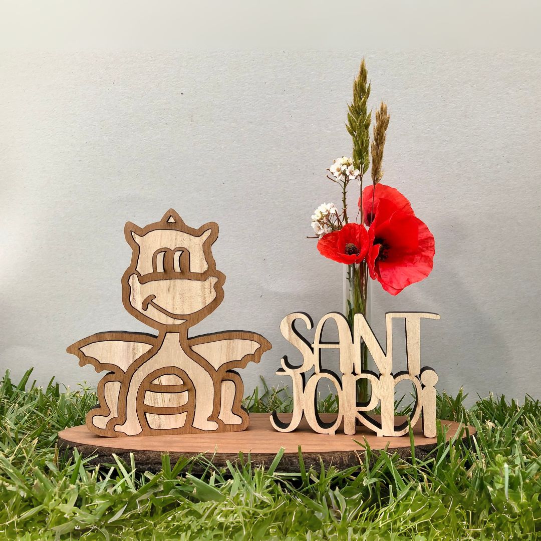 Figura de dragón de madera artesanal con base y flor natural, decoración sostenible de sobremesa inspirada en la leyenda de Sant Jordi, ideal para regalar o decorar en la Diada.