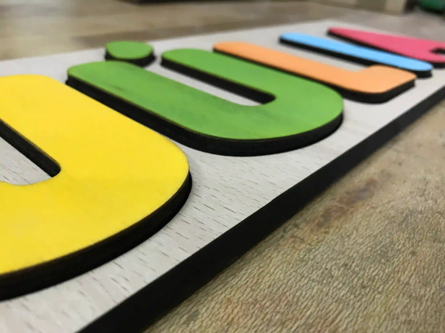 Juego infantil de madera para encajar letras. Personalizado con el nombre del niño o niña, las letras se pintan aleatoriamente para que combinen en conjunto. Detalle grosor