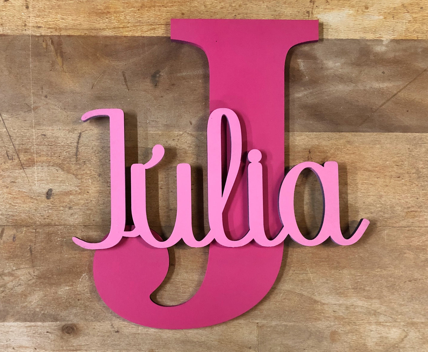 Nombre decorativo de madera, troquelado y montado sobre inicial de madera de chopo pintadas a dos colores para mayor contraste. Rosa sobre fucsia.