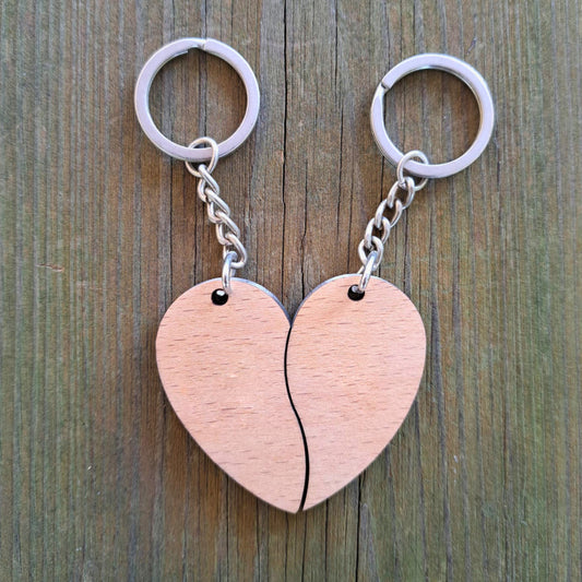 Pack de dos llaveros de madera que unidos forman un corazón. Personalizados a láser con una inicial en cada mitad.