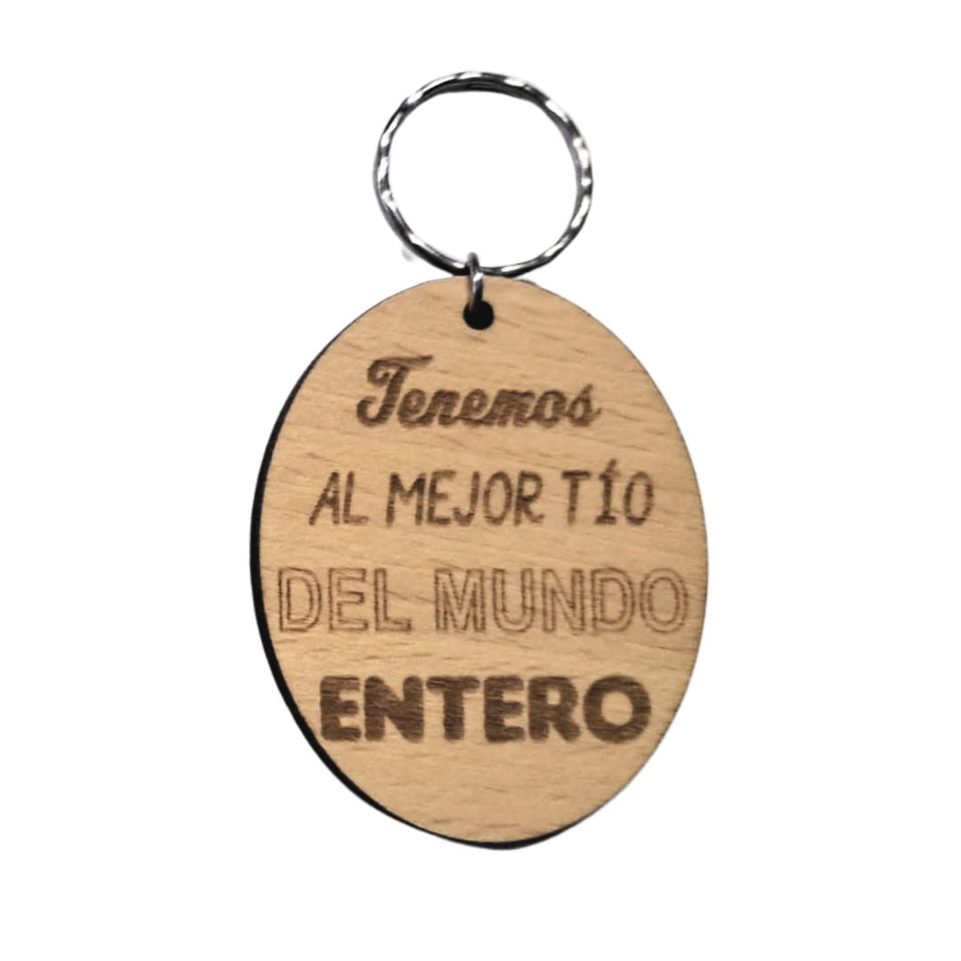 Llavero de madera de haya ovalado con la frase grabada a láser: Tenemos al mejor tío del mundo entero