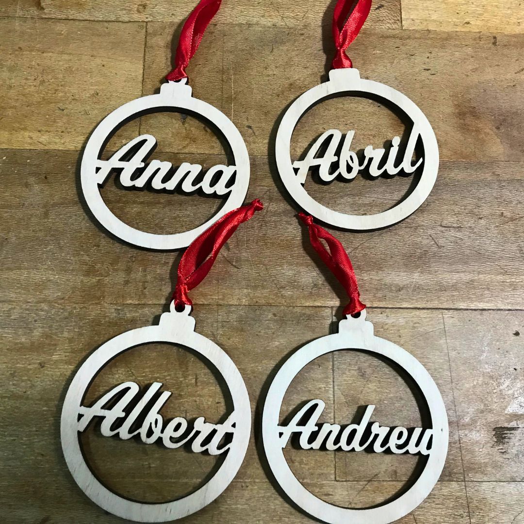 Bola para el árbol de navidad de madera de chopo personalizada con nombre troquelado en su interior. Elegante y minimalista. Incluye cinta roja para colgar en el árbol.