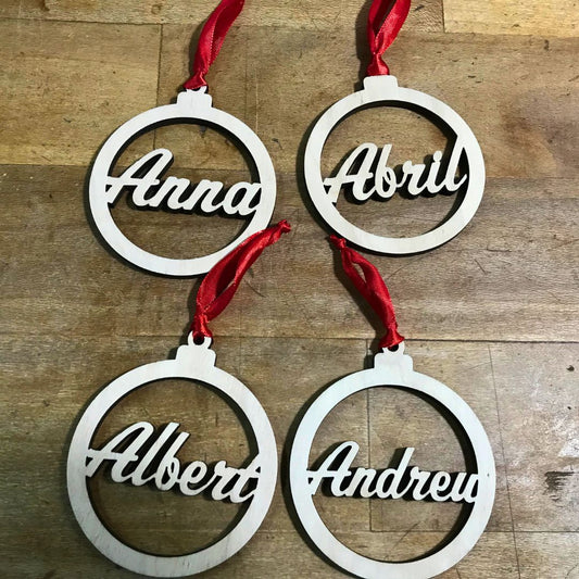 Bola para el árbol de navidad de madera de chopo personalizada con nombre troquelado en su interior. Elegante y minimalista. Incluye cinta roja para colgar en el árbol.