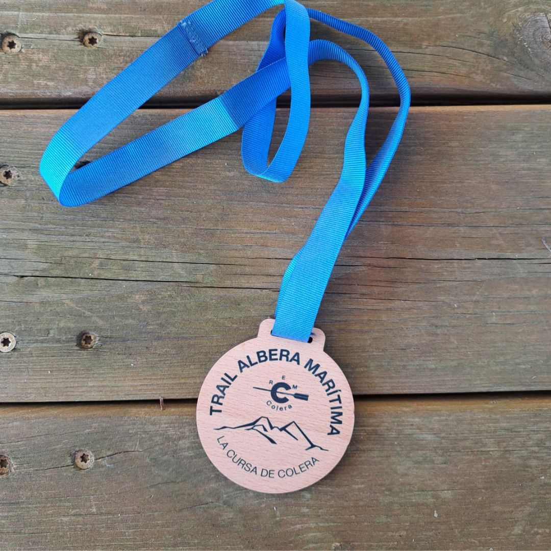 Medalla redonda de madera de chopo natural, personalizada con diseño impreso o grabado a láser y cinta grosgrain del color que mejor se adapte al diseño.