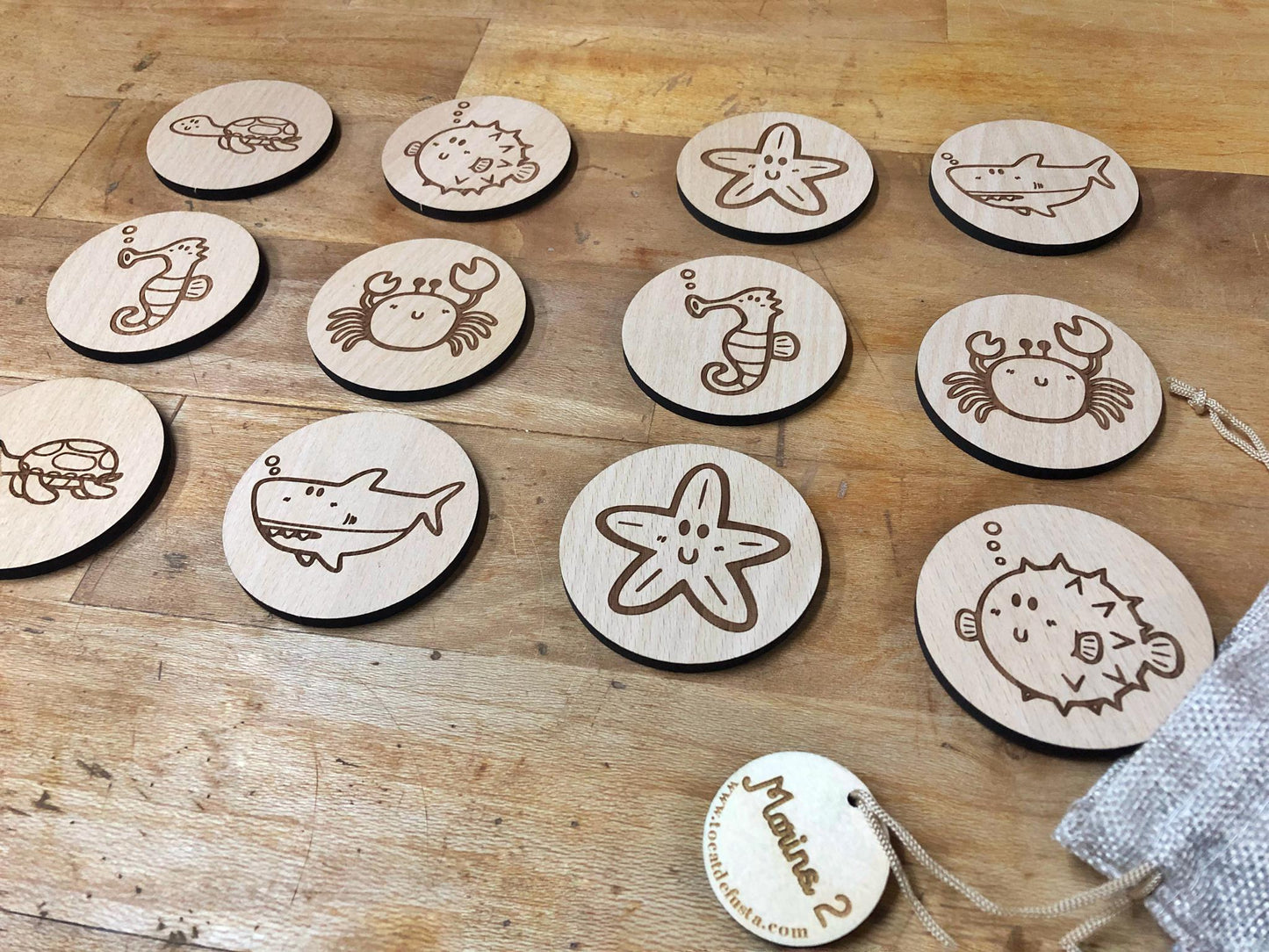 Juego de memoria de madera grabado con animales marinos, piezas redondas artesanales en bolsa de lino, juguete educativo y sostenible.