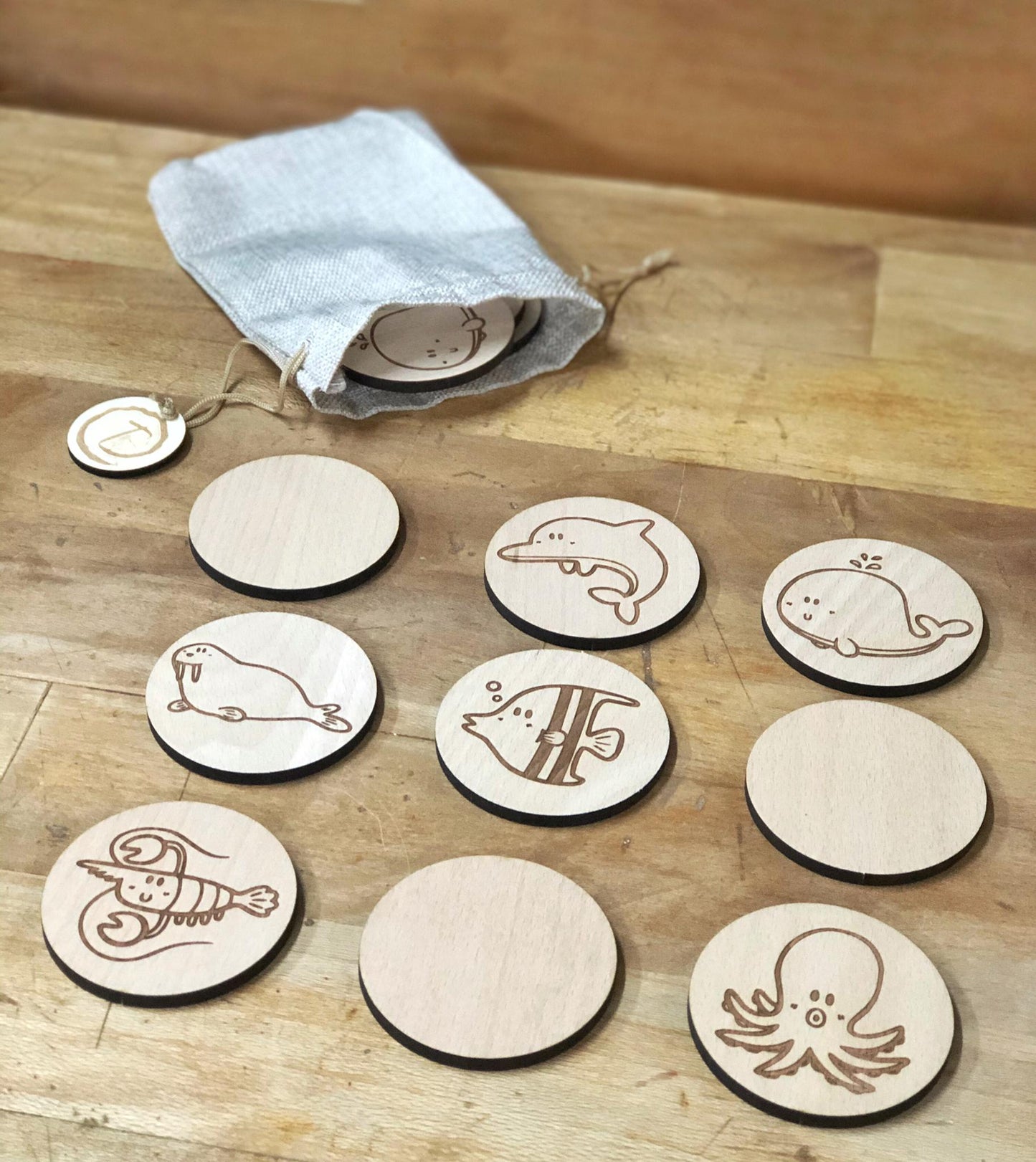 Juego de memoria de madera grabado con animales del océano, piezas redondas artesanales en bolsa de lino, juguete educativo y sostenible.