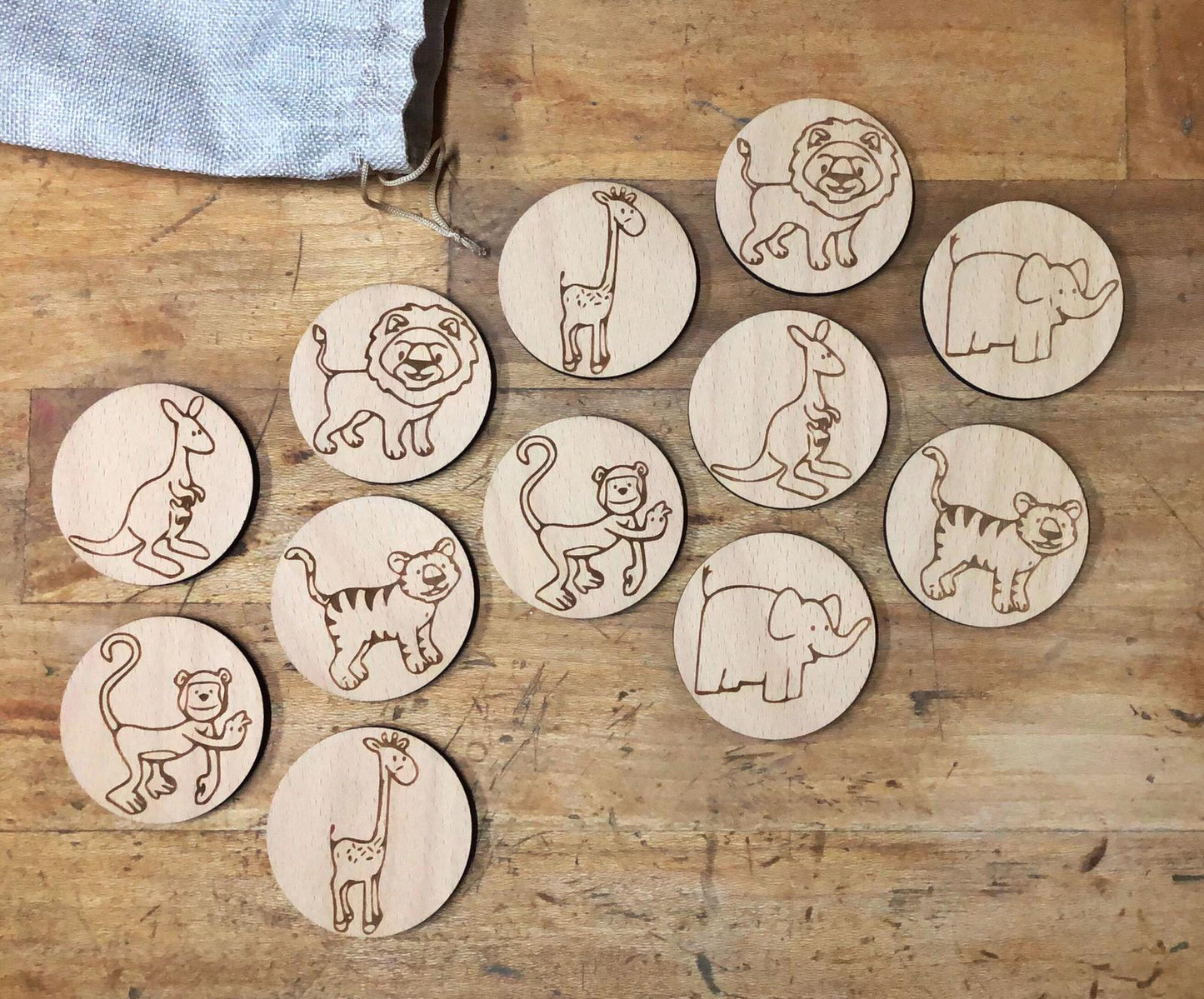Juego de memoria de madera grabado con animales de la selva, piezas redondas artesanales en bolsa de lino, juguete educativo y sostenible.