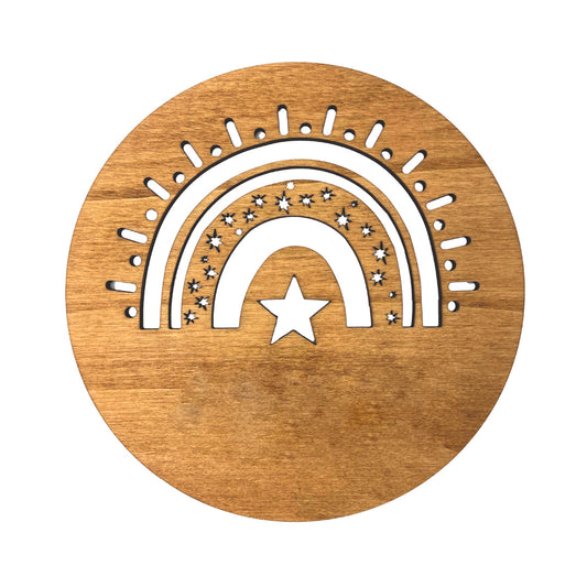 Placa de madera circular para colgar en la pared con detalle de arcoiris troquelado y personalizada con el nombre de la niña o niño en metacrilato blanco.