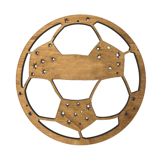 Detalle de la placa de madera en forma de balón de futbol preparada para añadir la personalización del nombre del destinatario