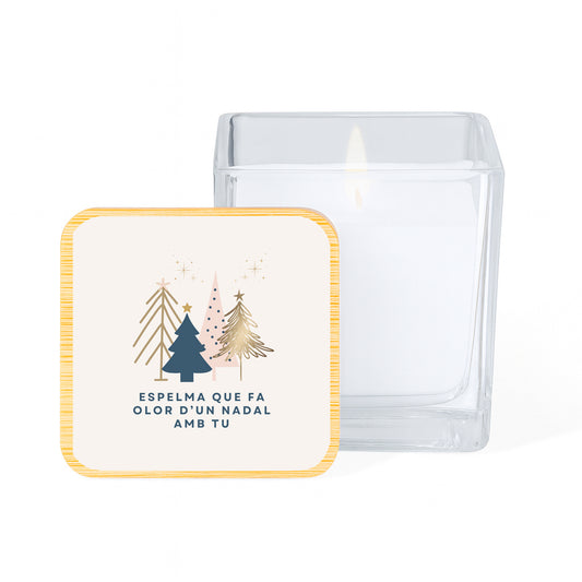 Vela con aroma de vainilla en tarro cuadrado de cristal y tapa de bambú impresa con un diseño blanco y limpio de fondo y siluetas de árboles de navidad con la frase Espelma que fa olor d'un nadal amb tu