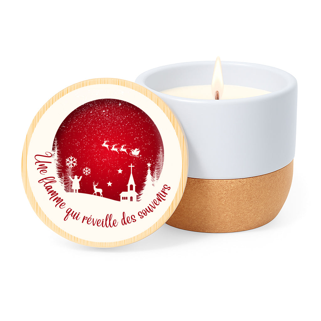 Vela con aroma de lino en tarro de cerámica con base de corcho y tapa de bambú impresa con diseño en blanco y rojo navideño con la silueta de Papá Noel con su trineo y la frase "Une flamme qui réveille des souvenirs"