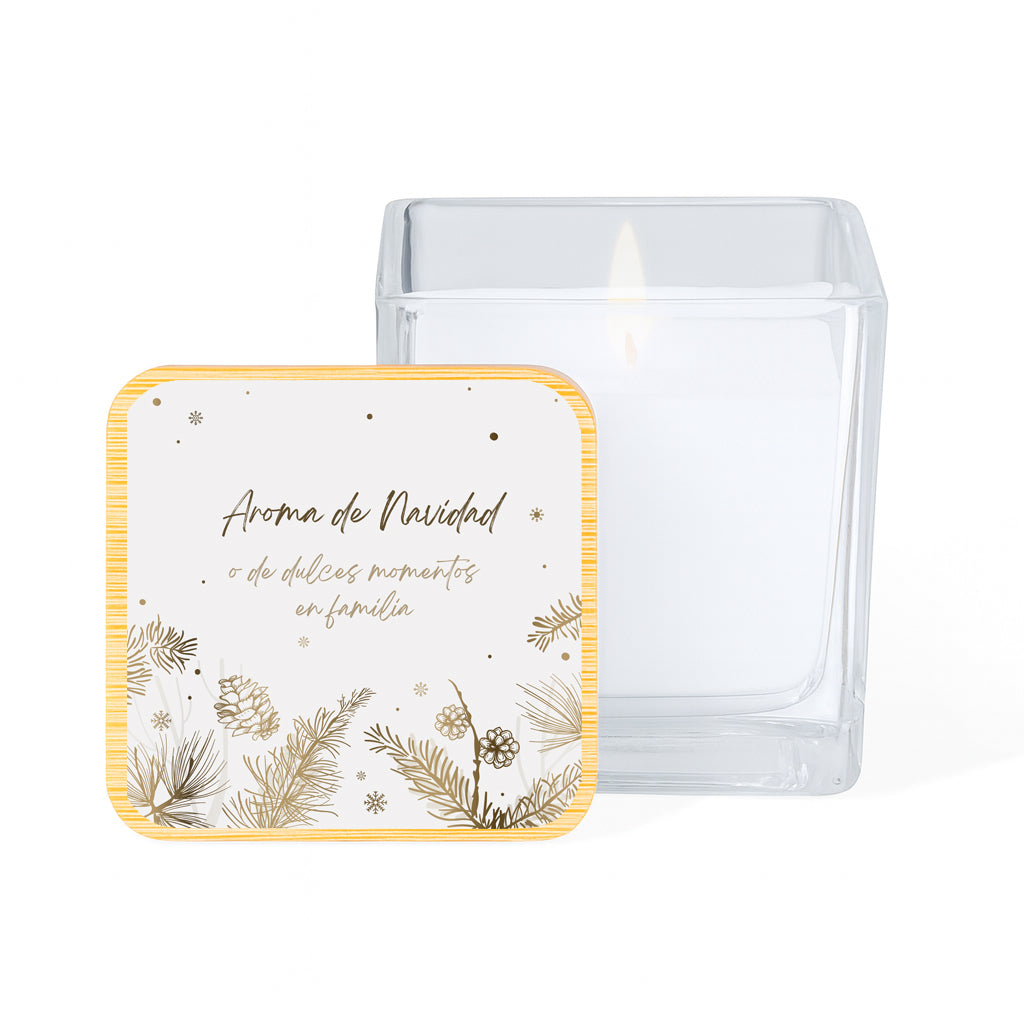 Vela con aroma de vainilla en tarro cuadrado de cristal y tapa de bambú impresa con un diseño navideño de piñas doradas sobre fondo blanco y la frase "Aroma de Navidad o de dulces momentos en familia"