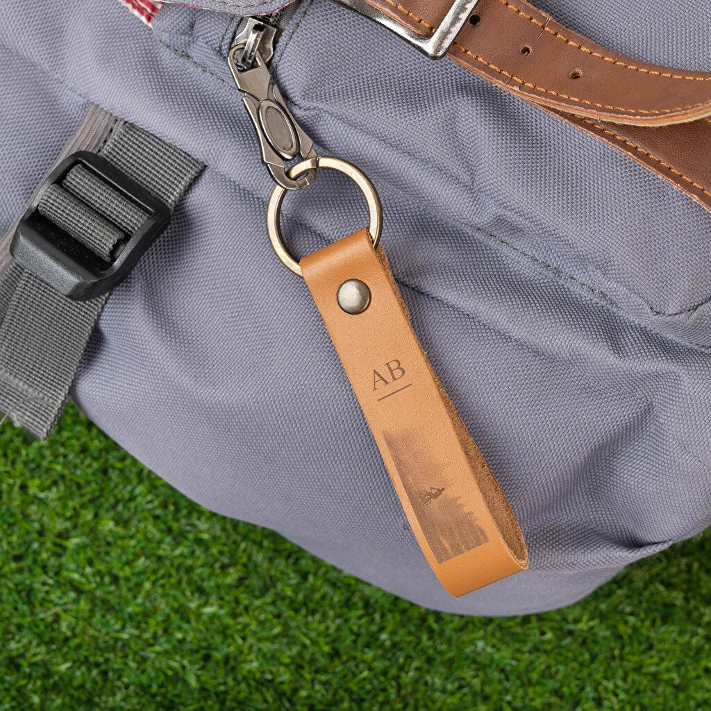 Llavero de cuero marrón de forma alargada con anilla de oro envejecido, grabado a láser