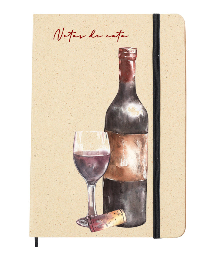 Portada del bloc de notas de hierba reciclada con goma elástica para mantenerla cerrada. Diseño de la portada: Ilustración tipo acuarela de una botella y copa de vino tinto. Acompaña la frase: Notas de cata