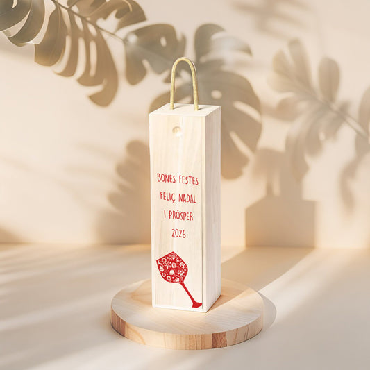 Caja de Madera para botella de vino, edición Navidad con dibujo de una copa de vino roja y el texto "Bones Festes, Feliç Nadal i Prósper 2026"