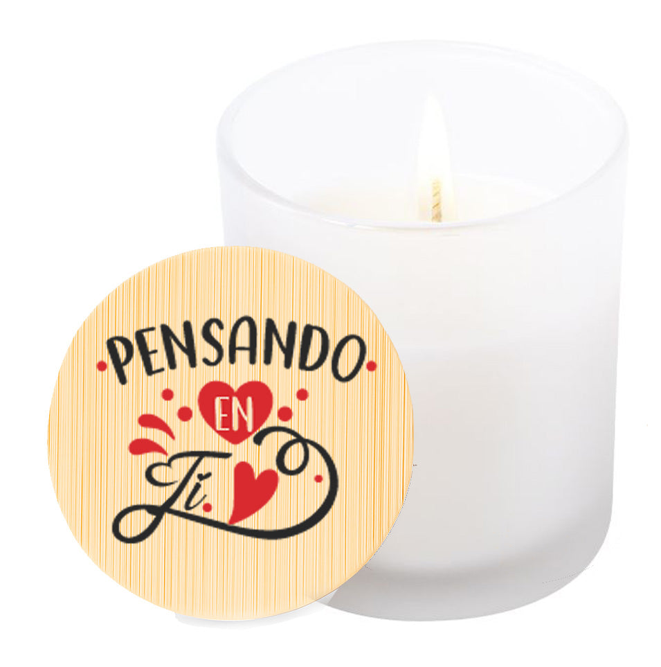 Vela aromática de vainilla en tarro de cristal translúcido con tapa de bambú y mensaje impreso en colores rojo y negro. Pensando en ti