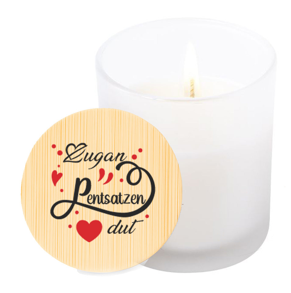 Vela aromática de vainilla en tarro de cristal translúcido con tapa de bambú y mensaje impreso en colores rojo y negro. Zugan Pentsatzen dut