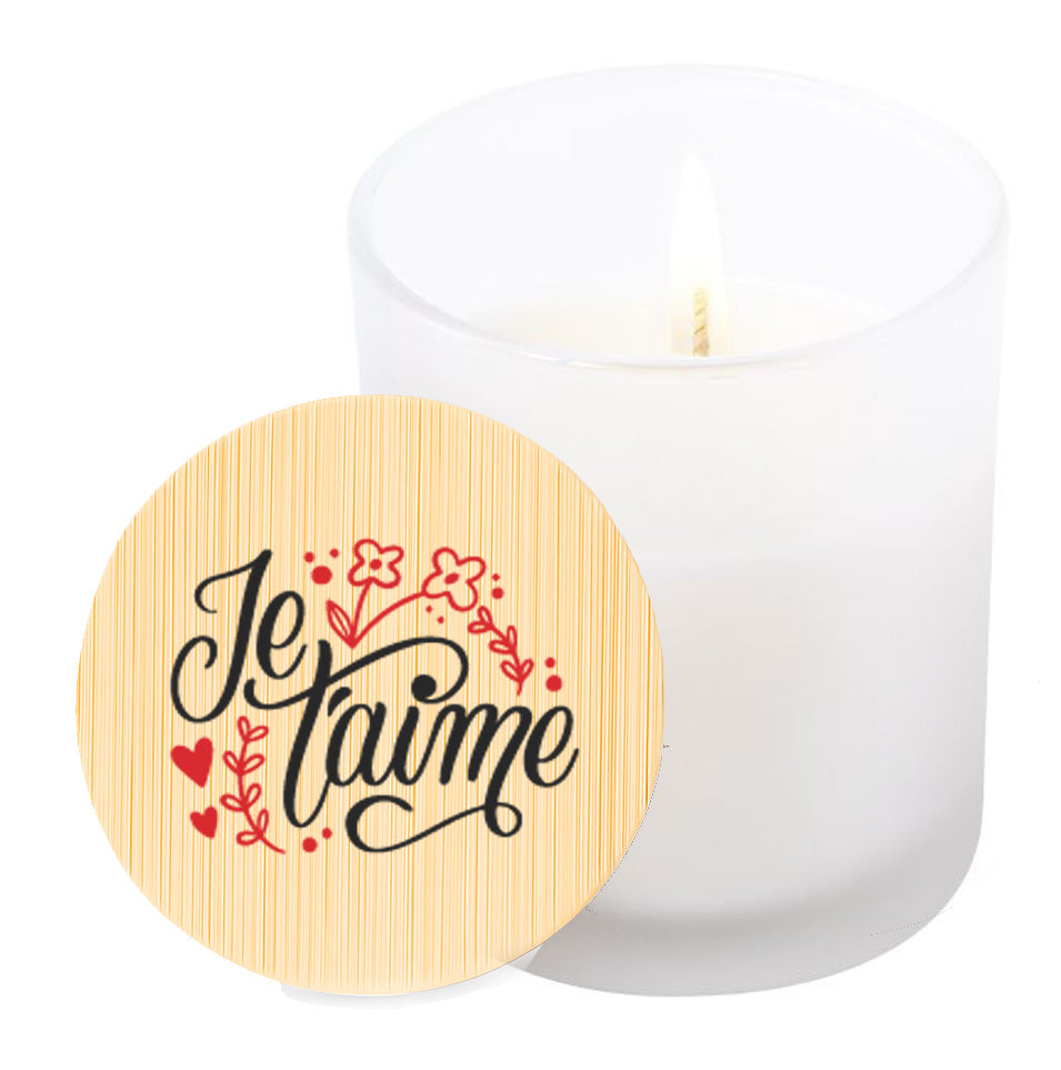 Vela aromática de vainilla en tarro de cristal translúcido con tapa de bambú y mensaje impreso en colores rojo y negro. Je t'aime