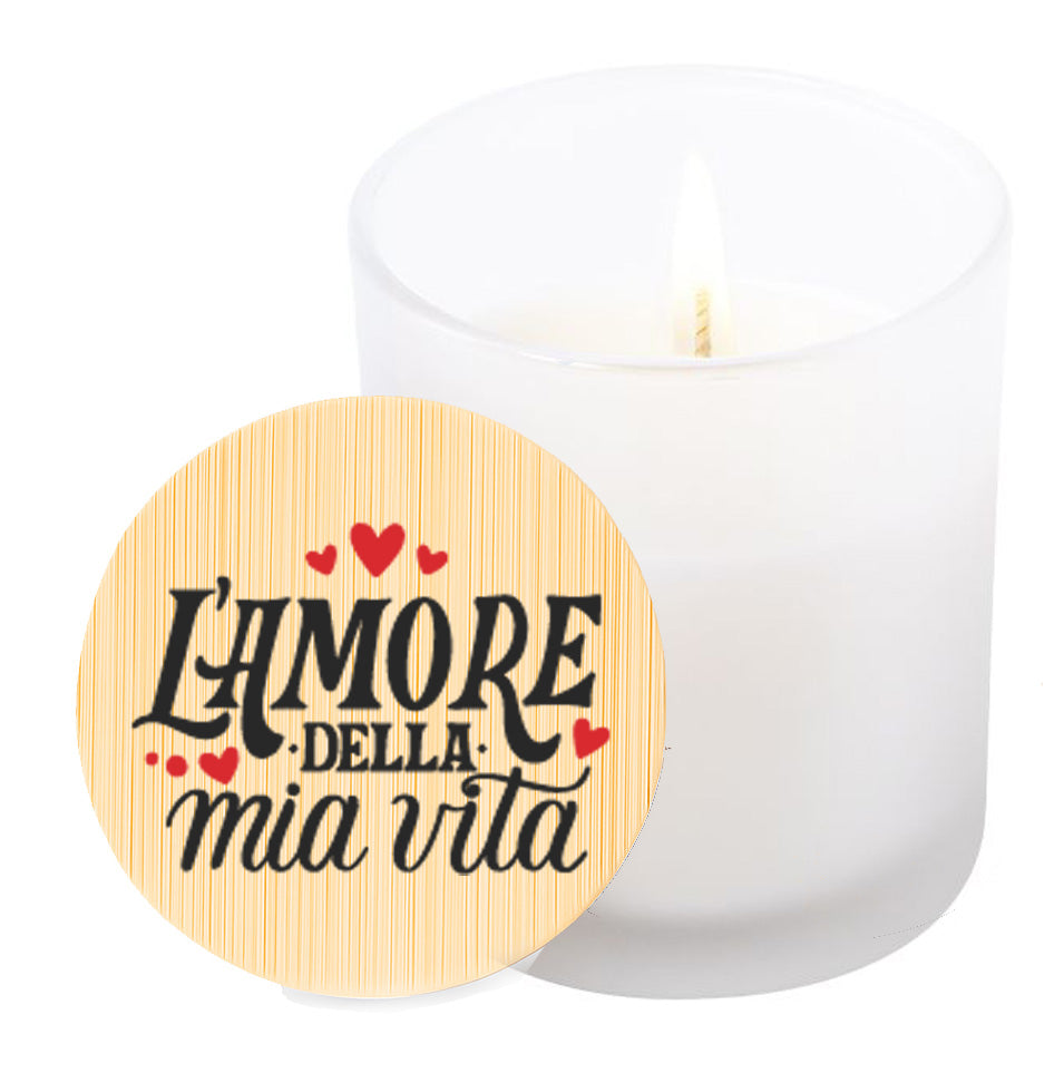 Vela aromática de vainilla en tarro de cristal translúcido con tapa de bambú y mensaje impreso en colores rojo y negro. L'amore della mia vita