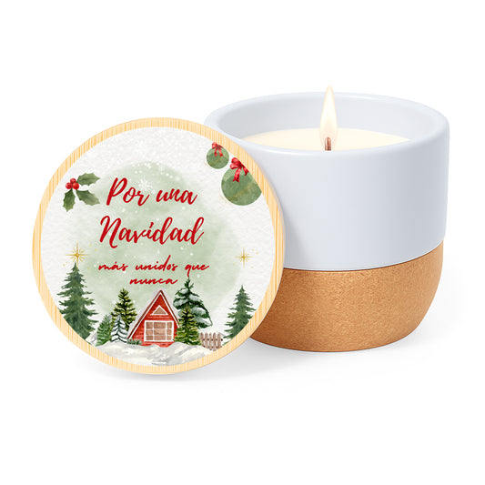 Vela con aroma de lino en tarro de cerámica con base de corcho y tapa de bambú impresa con un diseño de casitas y avetos nevados y la frase Por una Navidad más unidos que nunca.