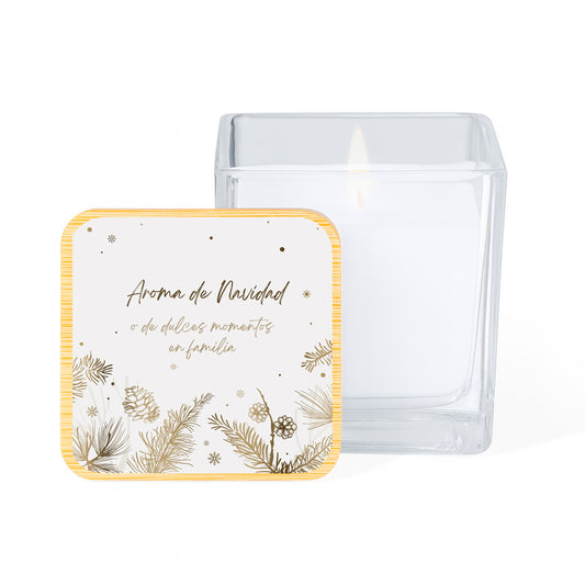 Vela con aroma de vainilla en tarro cuadrado de cristal y tapa de bambú impresa con un diseño navideño de piñas doradas sobre fondo blanco y la frase "Aroma de Navidad o de dulces momentos en familia"