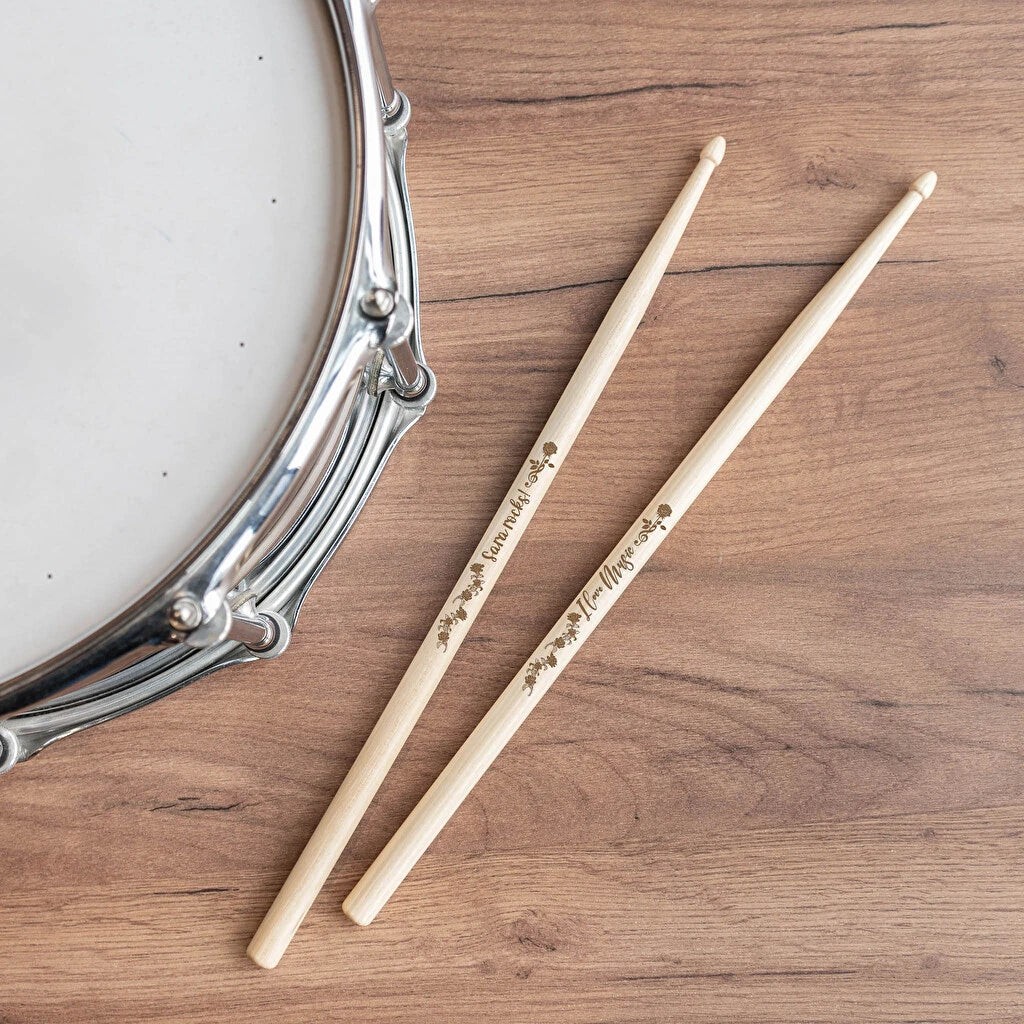 Dos baquetas para batería profesionales grabadas con texto distinto en cada una