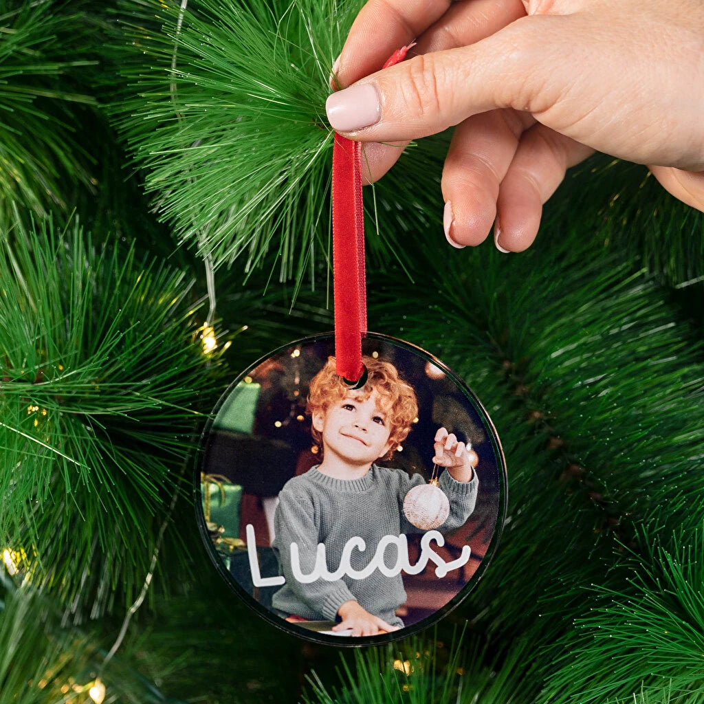 Adorno para el árbol de navidad de metacrilato en forma circular, personalizado con impresión directa a todo color, decorado con una cinta de terciopelo roja. 