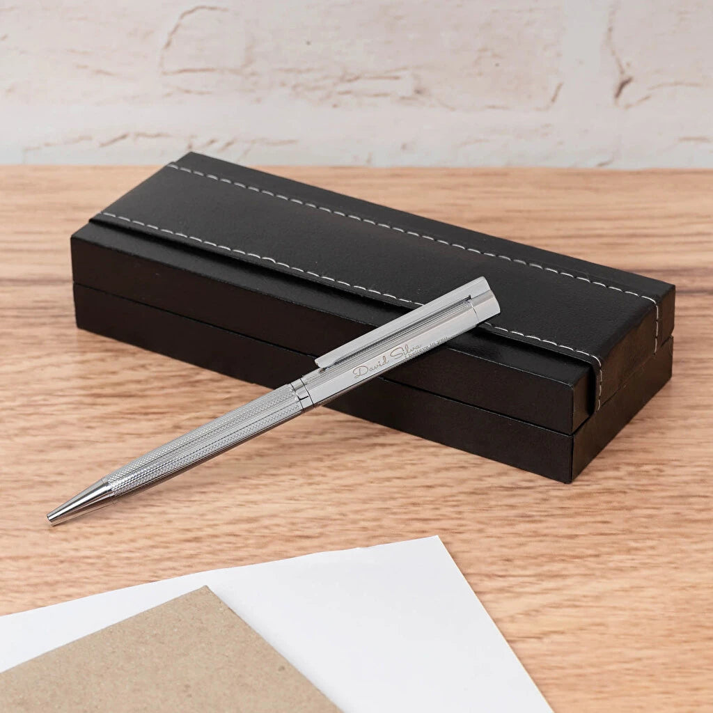 Bolígrafo metálico Seth con acabado plateado, estuche de polipiel y grabado láser personalizado. Ideal para regalos elegantes y detalles únicos.