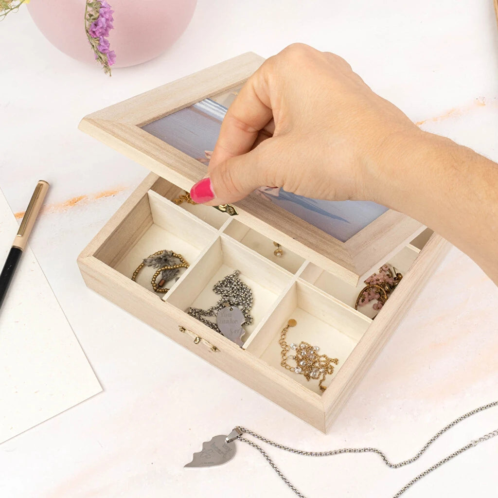 Caja de madera con compartimientos y tapa de metacrilato  abierta mostrando joyas en su interior