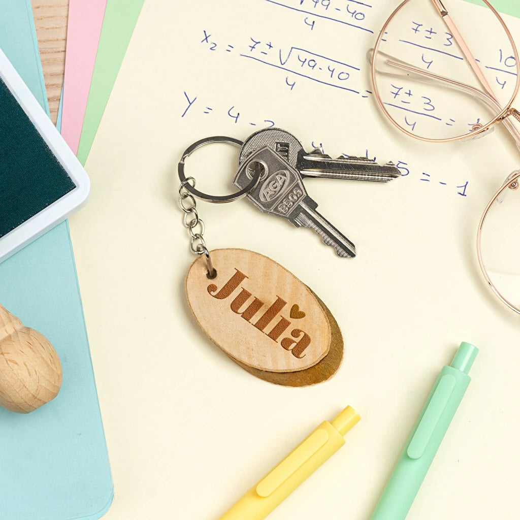 llavero de madera natural en forma de disco rústico grabado a láser por una cara. Forma ovalada.