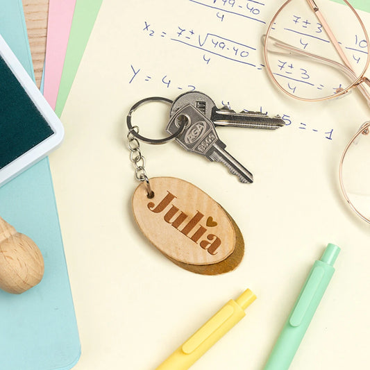 llavero de madera natural en forma de disco rústico grabado a láser por una cara. Forma ovalada.