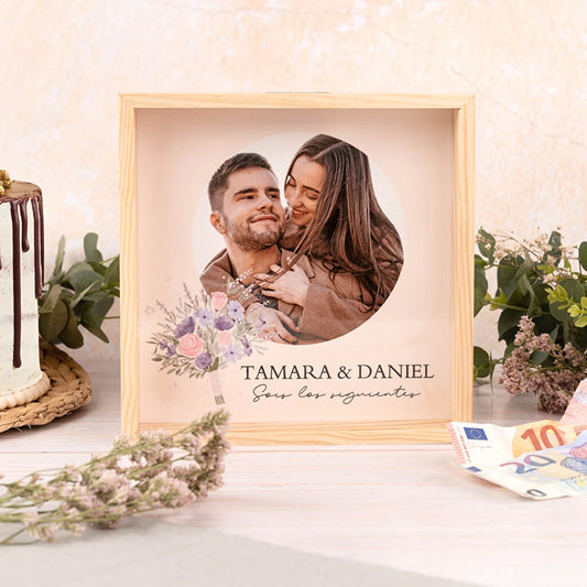 hucha de madera quadrada con frontal de metacrilato que permite ver la impresión del fondo, en este caso la foto de una pareja con un texto que los designa como los siguientes novios