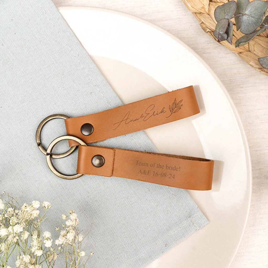 Llavero de cuero marrón de forma alargada con anilla de oro envejecido, grabado a láser a dos caras