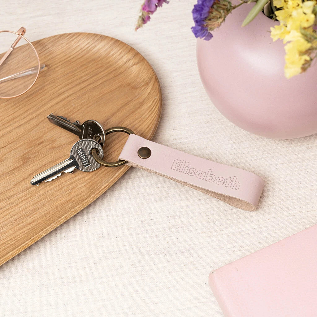 Llavero de cuero rosado de forma alargada con anilla de oro envejecido, grabado a láser 