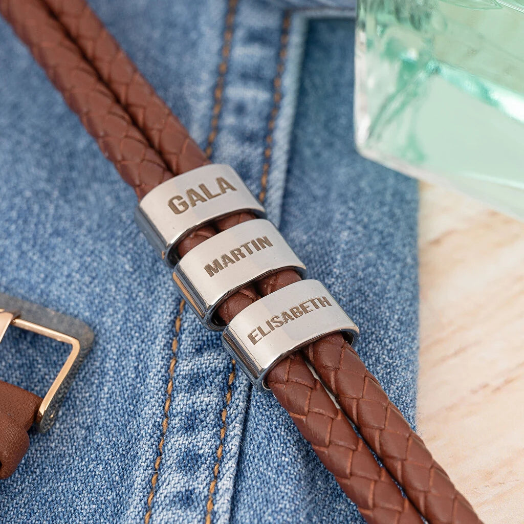 Pulsera de cuero trenzado personalizada con grabado en tres placas metálicas.