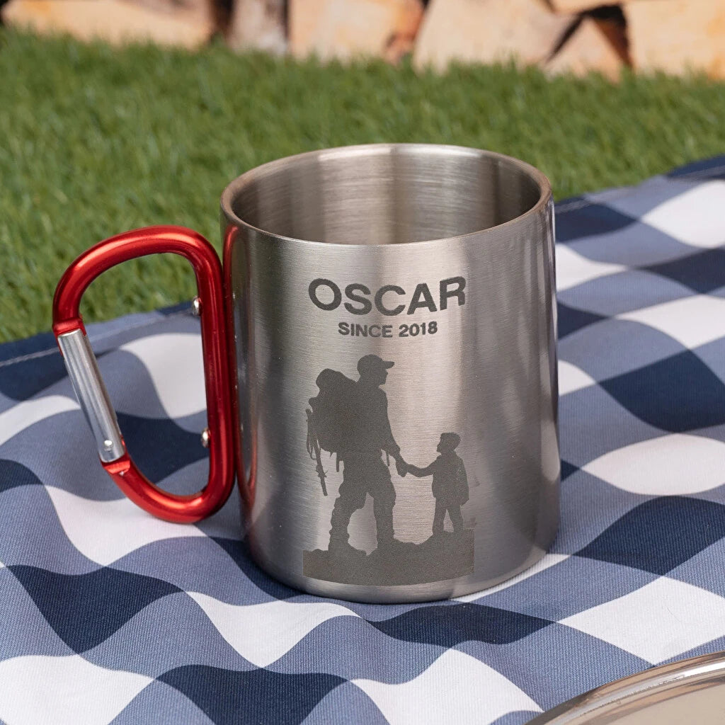 Taza de acero inoxidable con mosquetón y grabado personalizado. Ideal para camping, excursiones y montaña. Resistente, ligera y práctica.