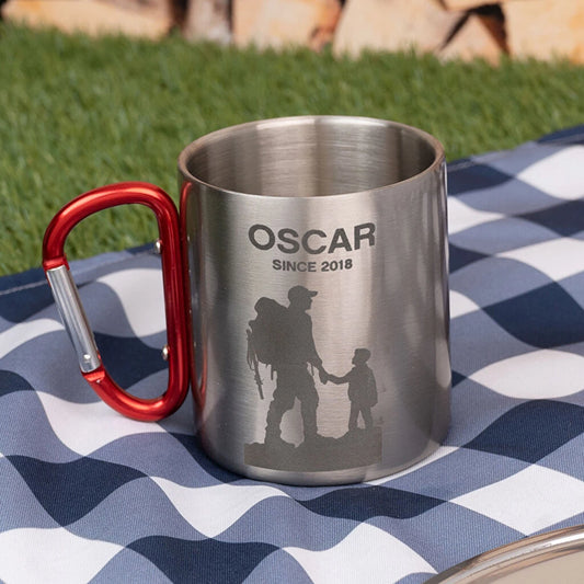 Taza de acero inoxidable con mosquetón y grabado personalizado. Ideal para camping, excursiones y montaña. Resistente, ligera y práctica.